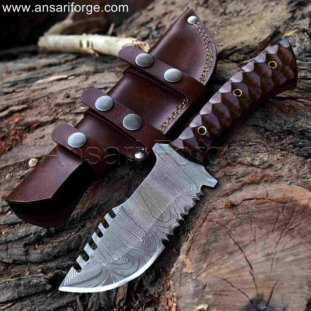 The Camper Damascus Tracker Knife, a hand-forged fixed blade knife with a walnut wood handle and a cowhide leather sheath.