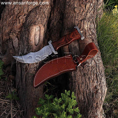 Damascus steel pirate dagger with curved blade, walnut wood handle, and leather sheath.