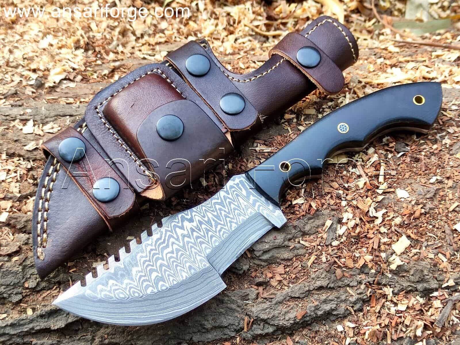 Custom Damascus Tracker Knife with hand-forged blade, black Micarta handle, and brown leather sheath. Overall length 11 inches.