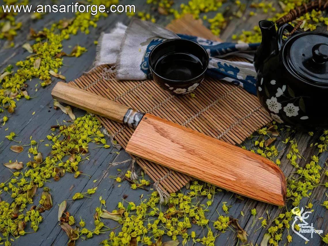 7-inch Santoku knife with its handmade oak wood sleeve on a cutting board.