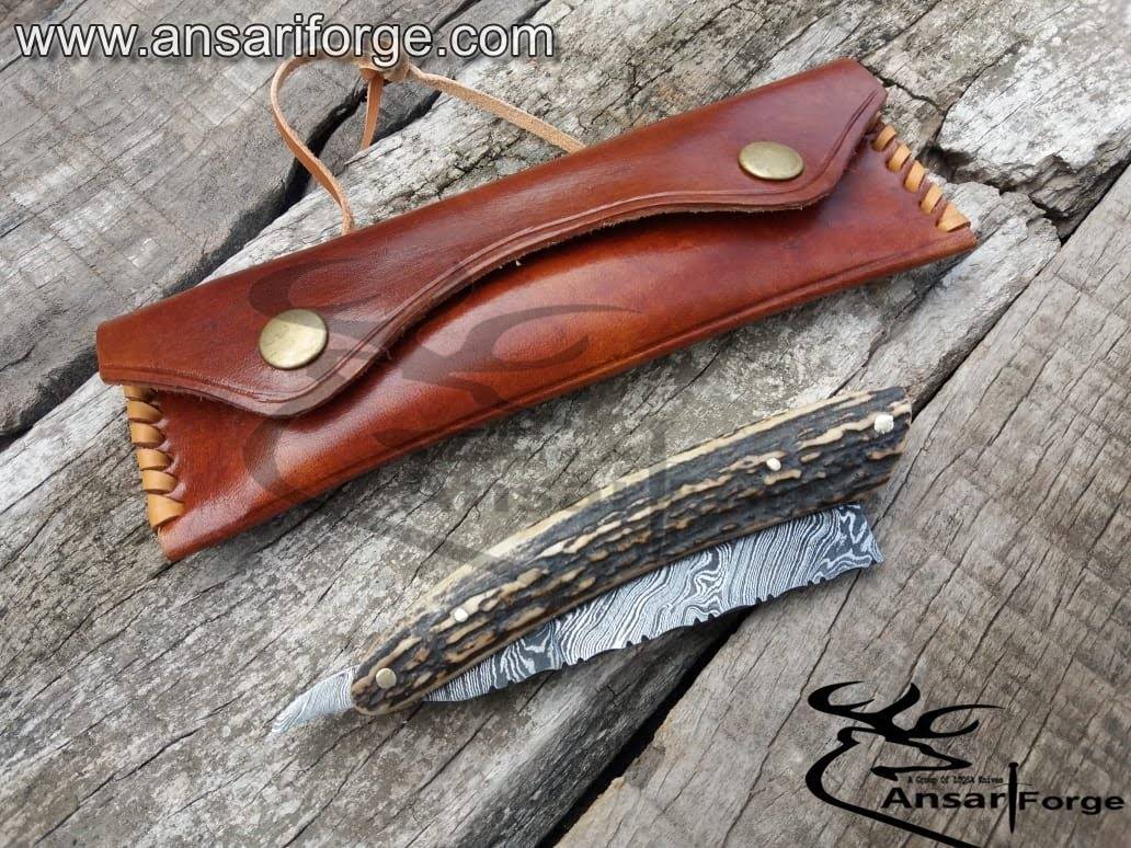 Straight razor with genuine antler handle and handmade leather sheath.