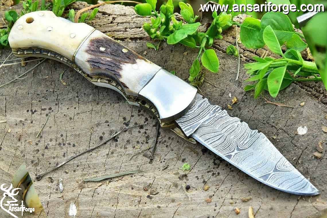 Camel bone and stag antler handle on a Damascus pocket knife.