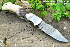 Camel bone and stag antler handle on a Damascus pocket knife.