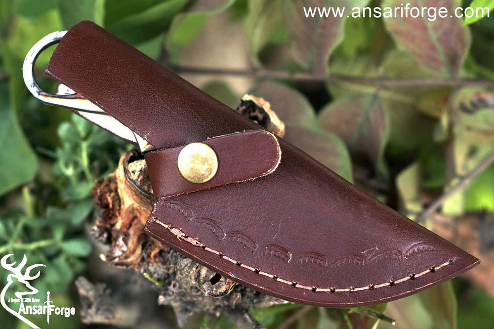 Gut hook knife displayed in its handmade cowhide leather sheath, emphasizing protection and rustic charm for outdoor adventures.
