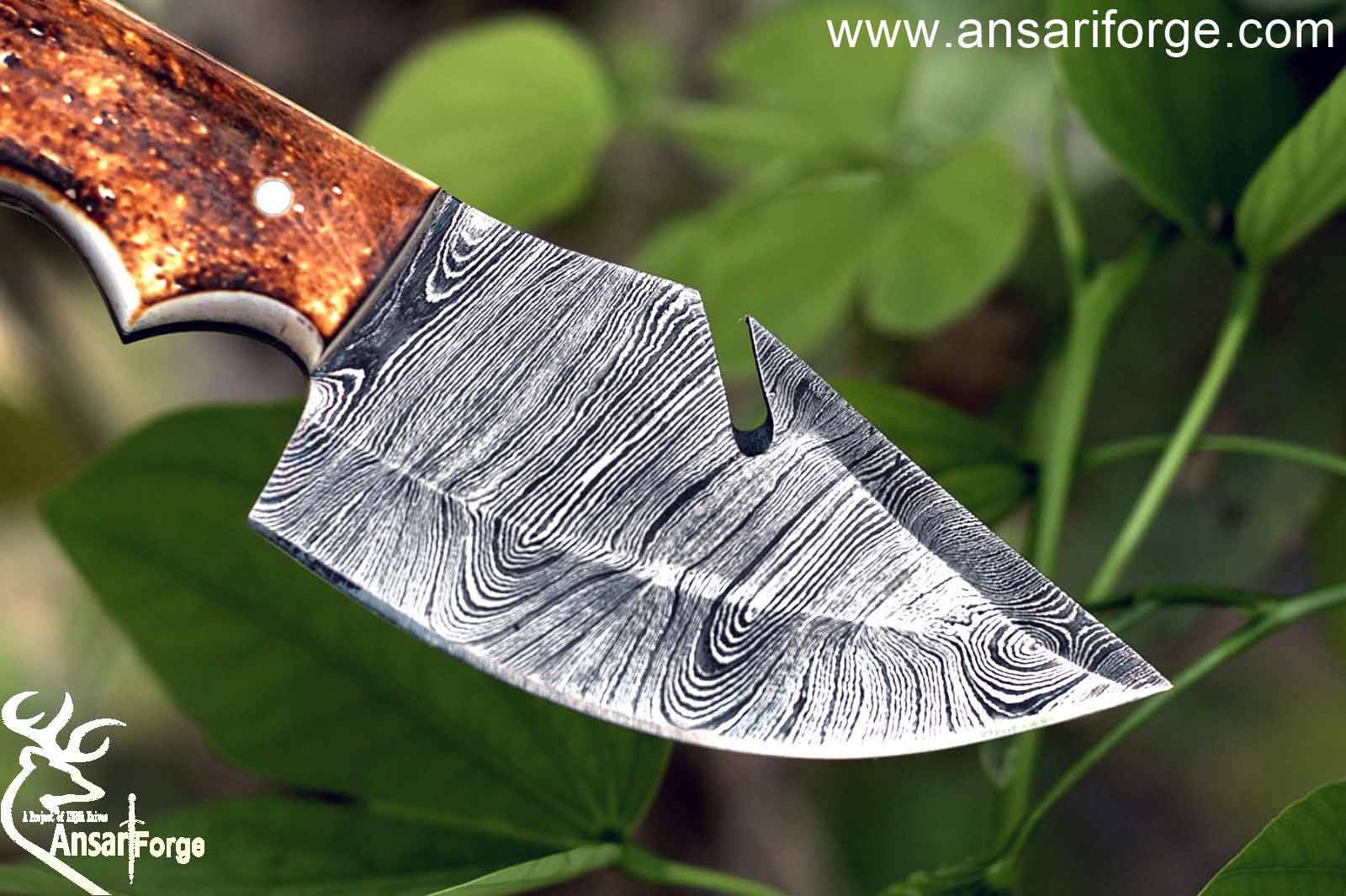 Close-up view of the 3.5-inch drop point blade of the Damascus knife with gut hook, highlighting the intricate Damascus steel layers and sharp edge.