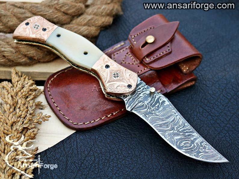 Handmade Damascus pocket knife with camel bone handle and folding clip point blade.