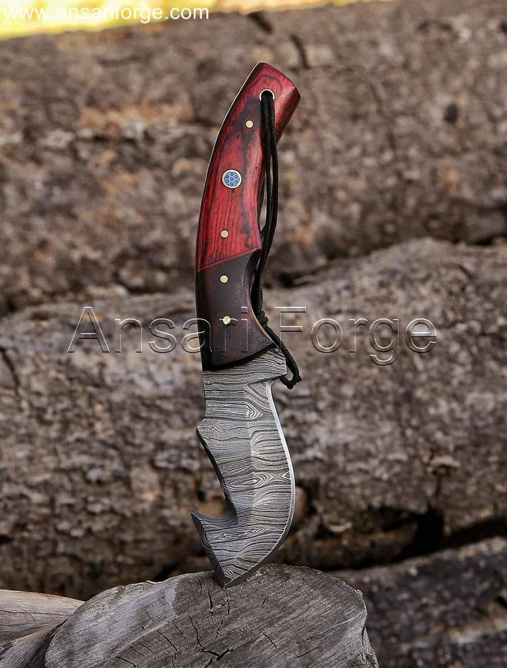 Hunter holding a Damascus Gut Hook Knife with a Pakkawood handle for a secure grip.