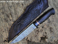 Hand forged Viking knife, Munin, by Ansari Forge. Damascus steel blade with ebony wood handle and cowhide leather sheath featuring a raven engraving.