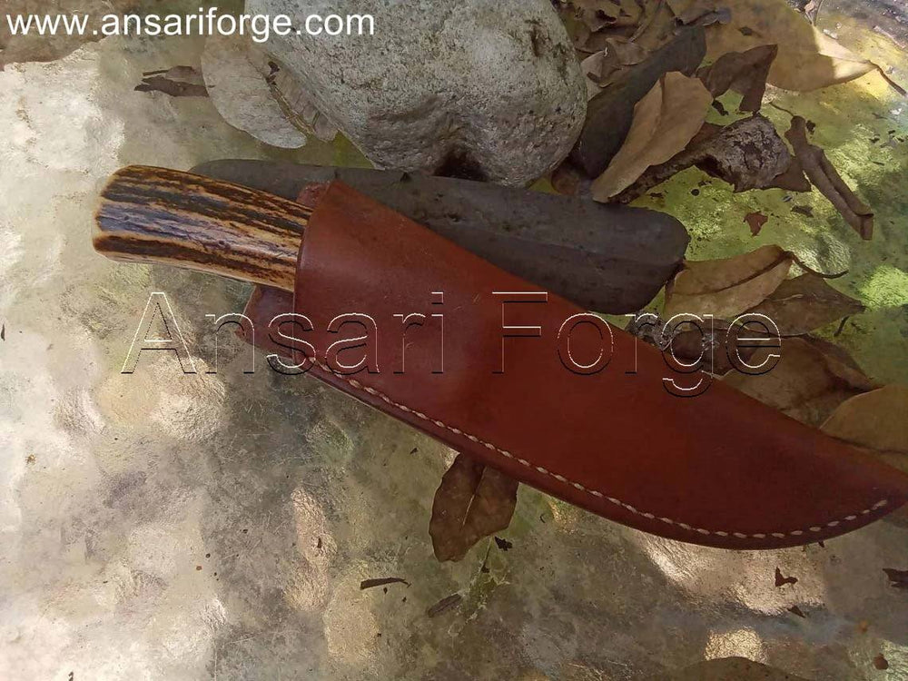 Handmade hunting knife with a drop point blade forged from 5160 steel and a natural stag antler handle.