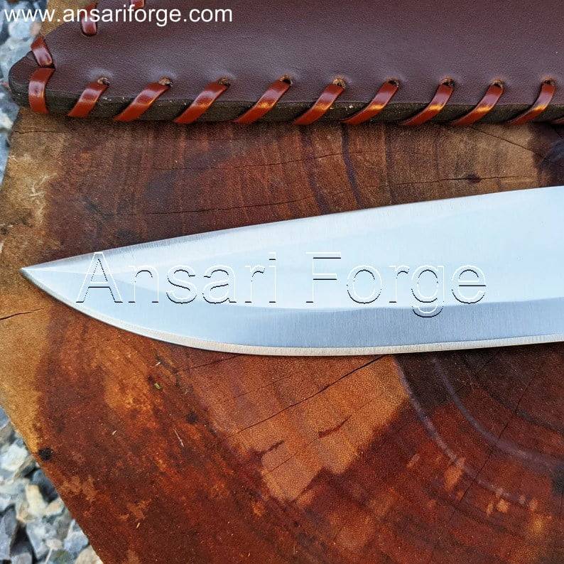 Close-up image of the Tombstone Bowie Knife's hand-forged 1095 blade showing its sharp edge and thickness.