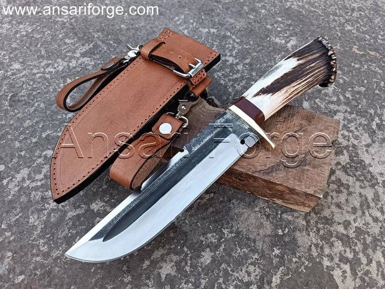 Hand-forged Bowie Knife with 5160 high carbon steel blade, stag antler handle, and brass guard, featuring a cowhide leather sheath