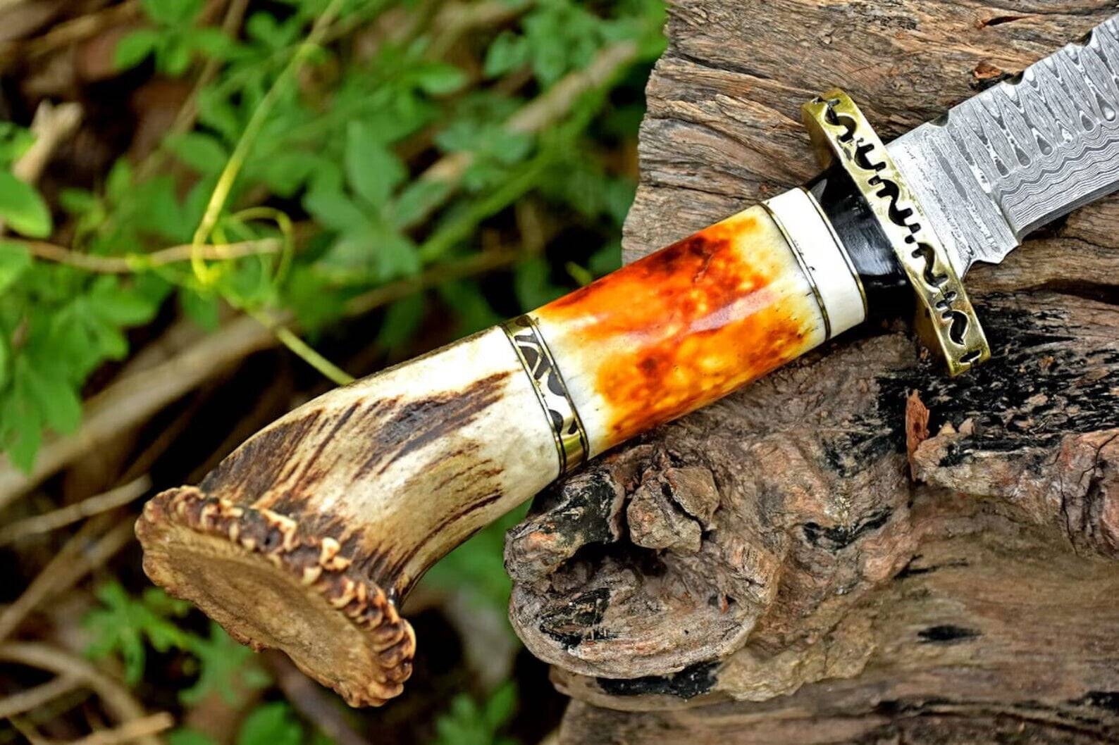 Detailed view of the Damascus Bowie knife's handle made from stag horn and camel bone, highlighting the craftsmanship and ergonomic design.
