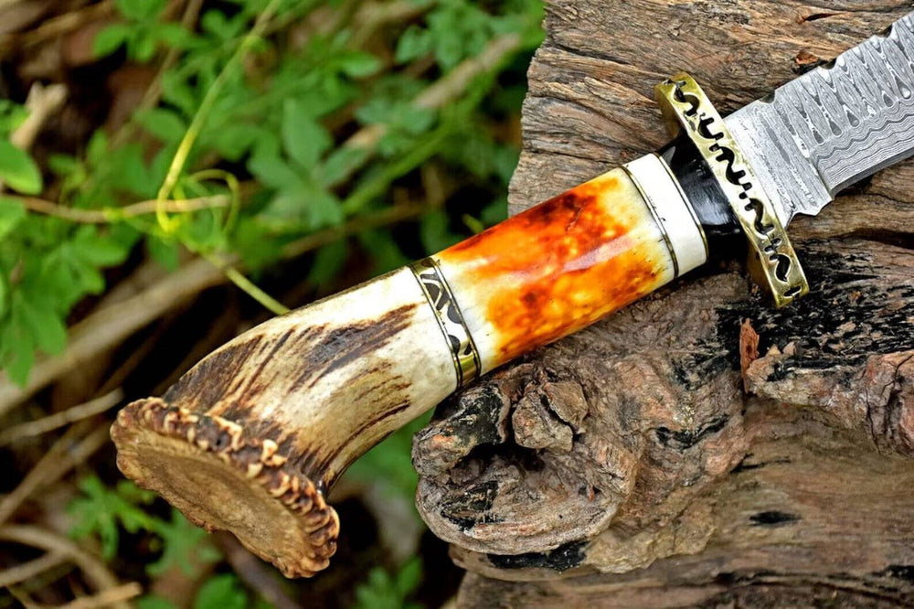 Detailed view of the Damascus Bowie knife's handle made from stag horn and camel bone, highlighting the craftsmanship and ergonomic design.