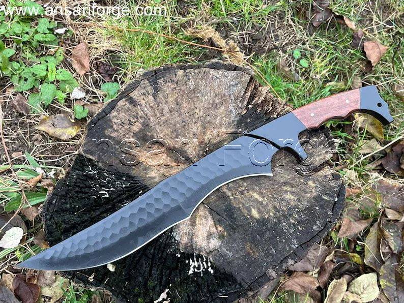 Large custom bowie knife, Jim Black, lying on a weathered wooden surface.