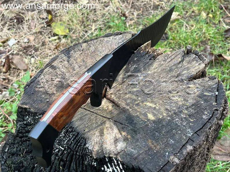 Jim Black custom Bowie knife with stainless steel bolsters and full tang design cutting the wood in jungle by an outdoors man