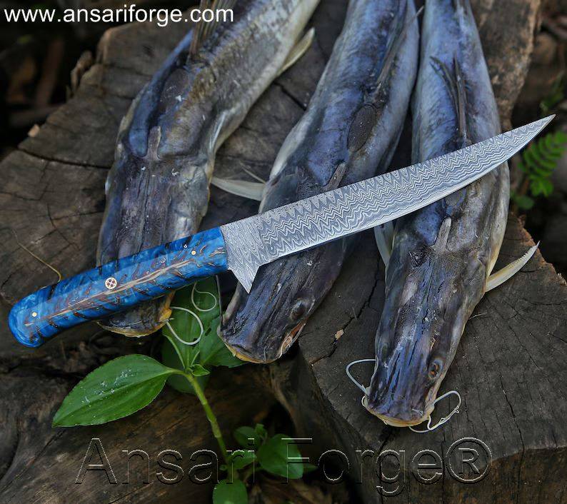 Fillet Fishing Knife Handmade Damascus Steel Knife With Flexible Blade laying on cat fish