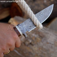 A hunter cutting the rope with Damascus hunting knife in jungle.