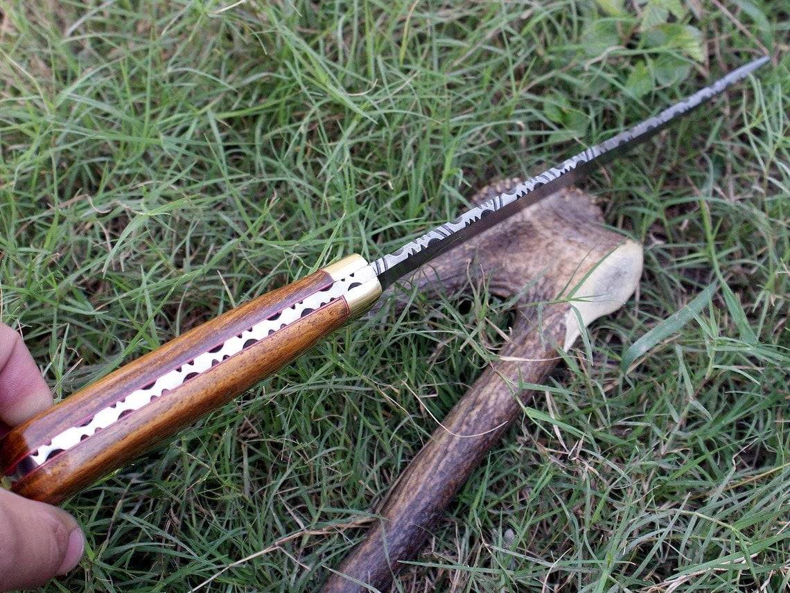 Custom Damascus steel Hunting Bowie knife with a clip point blade, highlighting the full tang construction and elegant rosewood handle.