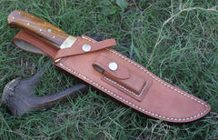Handcrafted Bowie knife featuring a rain drop Damascus pattern blade, rosewood handle, and brass finger guard, displayed alongside its handmade leather sheath.