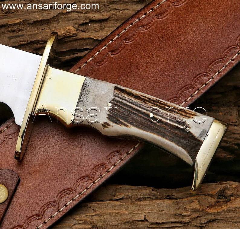 15 inch custom stag handle bowie knife with leather sheath. D2 steel clip point blade, full tang construction for strength. Handmade with brass guard, ideal for hunting, camping, or collection.