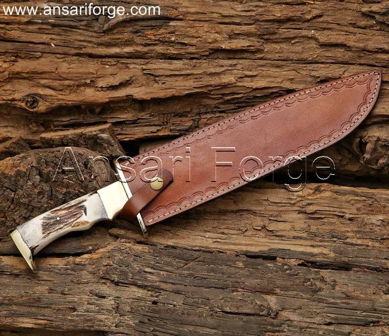 15 inch custom stag handle bowie knife with leather sheath. D2 steel clip point blade, full tang construction for strength. Handmade with brass guard, ideal for hunting, camping, or collection.