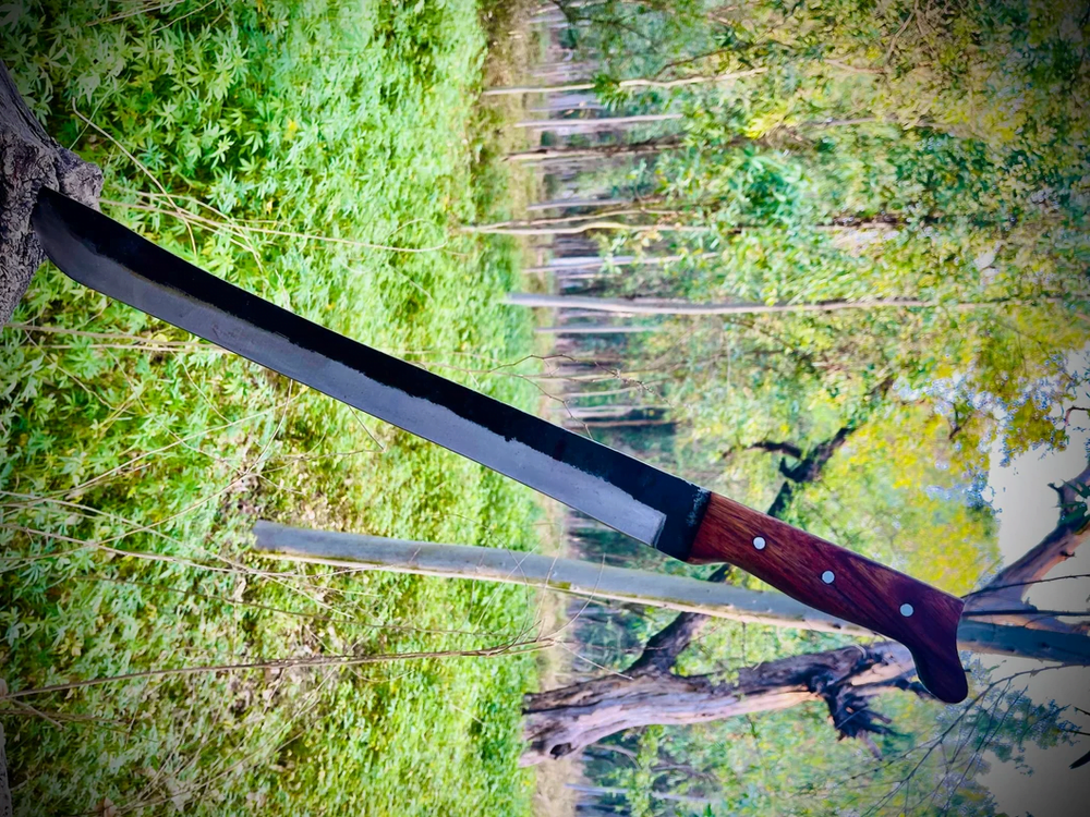 Hand-forged 1095 high carbon steel machete knife with rosewood handle and leather sheath.