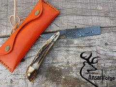 Hand-forged Damascus steel straight razor with antler handle.