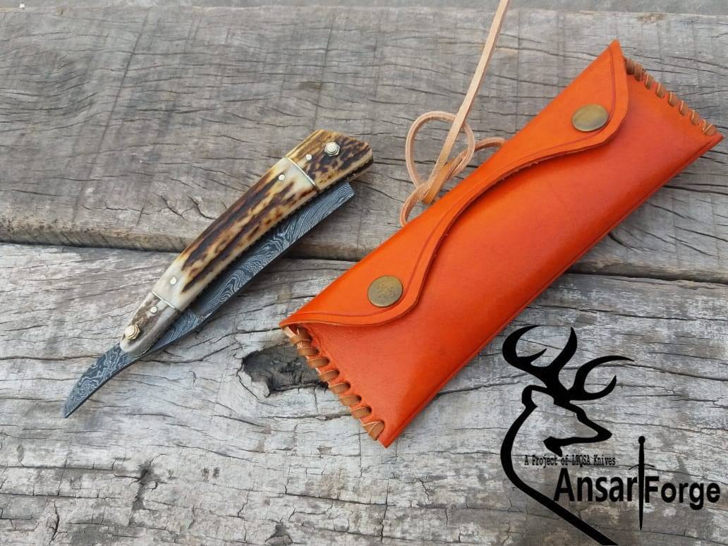 Hand-forged Damascus steel straight razor with antler handle.