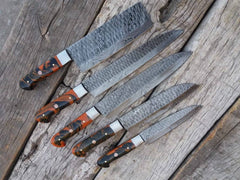 Premium Damascus kitchen knife set displayed on a wooden countertop.