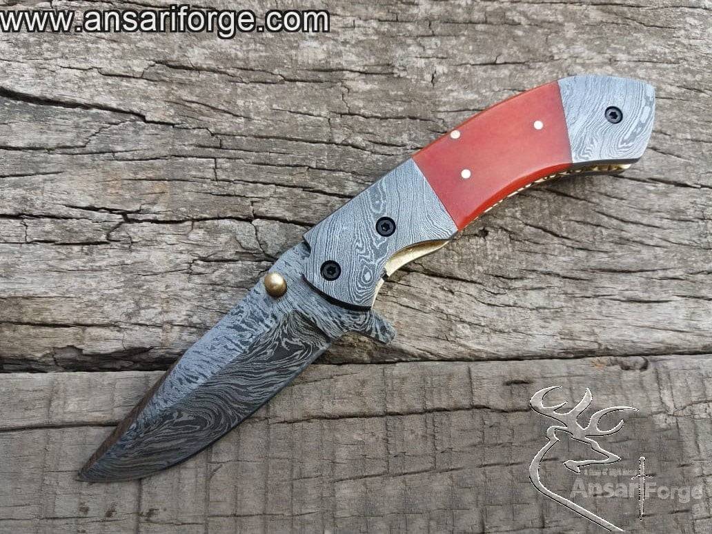 Ansari Forge Folding Utility Knife showcasing hand-forged 1095 and 15N20 Damascus steel with a fire pattern.
