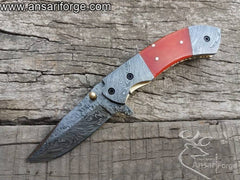 Ansari Forge Folding Utility Knife showcasing hand-forged 1095 and 15N20 Damascus steel with a fire pattern.