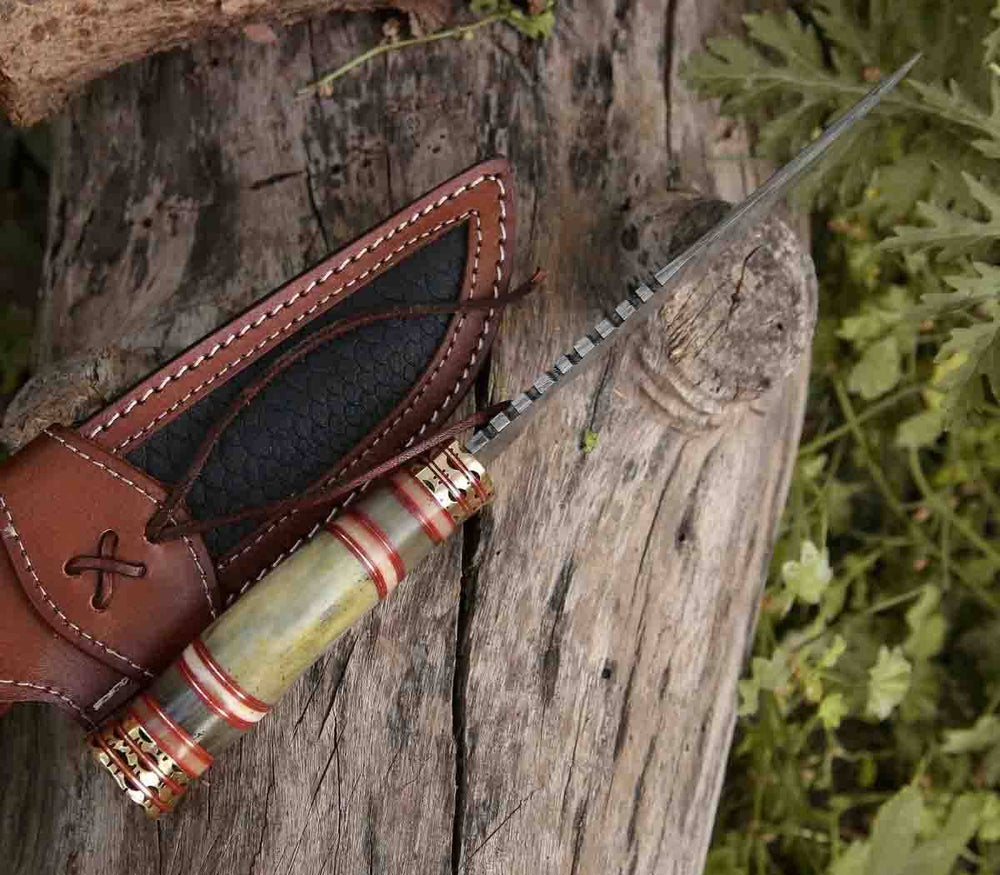 The "Razor's Edge" knife in its entirety, with the bone handle, brass hilt, and leather sheath visible.