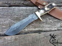White Deer Antler Handle Real Damascus Knife in its entirety, including the full tang construction, spear point blade, and brass hilt resting in a brown leather sheath.