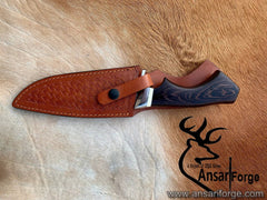 Hand forged Damascus knife with patterned steel blade, dark wood handle, and leather sheath - Ansari Forge custom outdoor tool for hunting and survival.