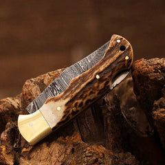 Damascus pocket knife, demonstrating its ergonomic design and compact size.
